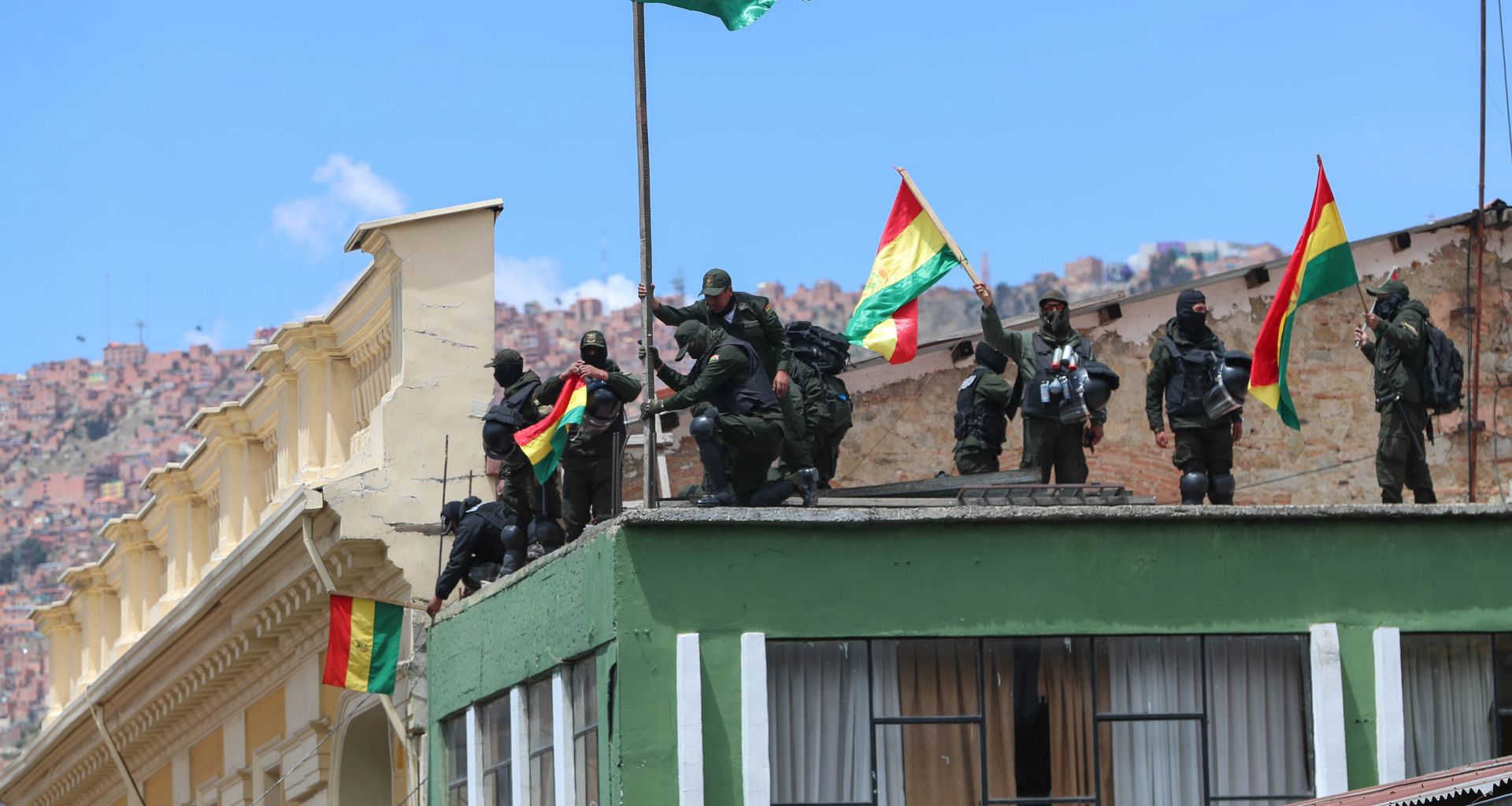 epa07984039 Policemen demonstrate with Bolivian flags after retreating to a unit near Murillo Square, where the headquarters of the Bolivian Government and Legislative are located, one day after the uniformed in several regions mutinied, in La Paz, Bolivia, 09 November 2019.  EPA/MARTIN ALIPAZ