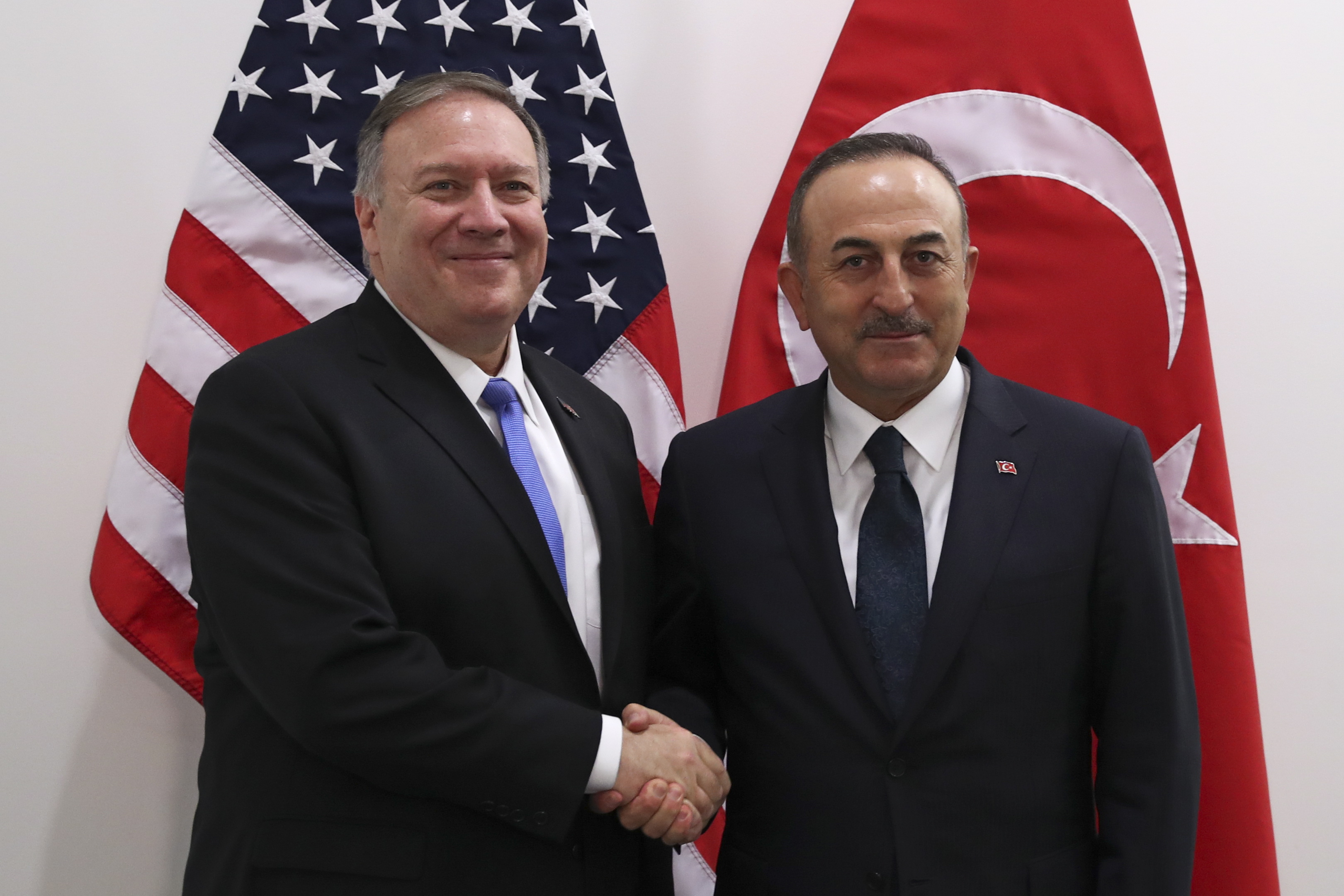 epa08011457 U.S. Secretary of State Mike Pompeo (L) shakes hands with Turkey's Foreign Minister Mevlut Cavusoglu during a NATO Foreign Ministers meeting at the NATO headquarters in Brussels, Belgium 20 November 2019.  EPA/Francisco Seco / POOL