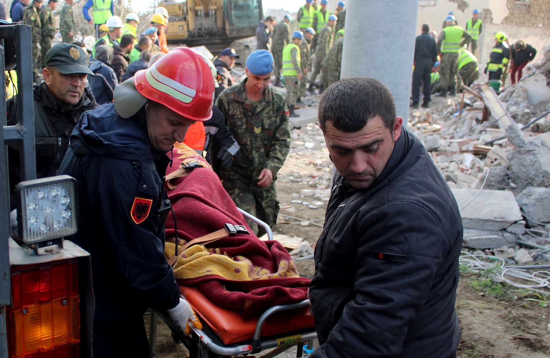 epa08028459 Rescue teams of fire fighters and police transport recovered bodies from the rubble of a building in Thumane, Albania, 27 November 2019. Albania was hit by a 6.4 magnitude earthquake on 26 November 2019, leaving until now over 30 people dead and 200 injured.  EPA/MALTON DIBRA