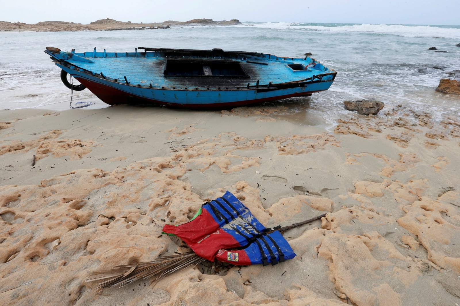 FILE PHOTO: A boat used by migrants is seen near the western town of Sabratha FILE PHOTO: A boat used by migrants is seen near the western town of Sabratha, Libya March 19, 2019. REUTERS/Ismail Zitouny/File Photo Ismail Zetouni