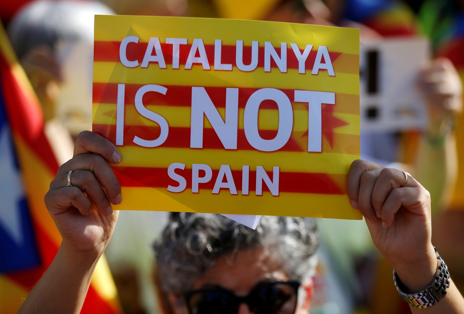 FILE PHOTO: A protester holds a poster with the slogan "Catalunya is not Spain" during a demonstration to ask for the Parliament inclusion of the 3 Catalan elected MEP's in front of the European Parliament in Strasbourg FILE PHOTO: A protester holds a poster with the slogan "Catalunya is not Spain" during a demonstration to ask for the Parliament inclusion of the 3 Catalan elected MEP's Puigdemont, Oriol Junqueras and Toni Comin, in front of the European Parliament in Strasbourg, France, July 2, 2019. REUTERS/Vincent Kessler/File Photo Vincent Kessler
