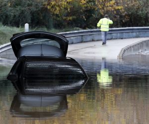 epa08039300 A submerged car remains in the middle of a flooded street after heavy rainfalls that hit Alpes-Maritimes department overnight in Mandelieu, France, 02 December 2019.  EPA/SEBASTIEN NOGIER