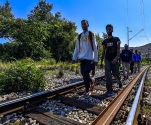 epa08046467 Undocumented migrants walk on the rail tracks during their journey towards western Europe, after resting at Lenche Zdravkin's house in Veles, Republic of North Macedonia on 14 August 2019 (issued on 05 December 2019). Lenche Zdravkin has welcomed thousands of refugees and migrants who have passed through North Macedonia on their route towards western Europe. At her home in Veles, located on a train line that the migrants use to guide their path, the travelers can find shelter, food and water, as well as a place to rest and recover before continuing their arduous journey. But perhaps most importantly, they find warmth and sympathy from a kind stranger. 'I see my children in all of the boys that come to my home,' Lenche says, who is also known by migrants as 'Mother Lenche', the 'Woman of the Railways'and 'Angel of the Refugees'.  EPA/GEORGI LICOVSKI  ATTENTION: This Image is part of a PHOTO SET