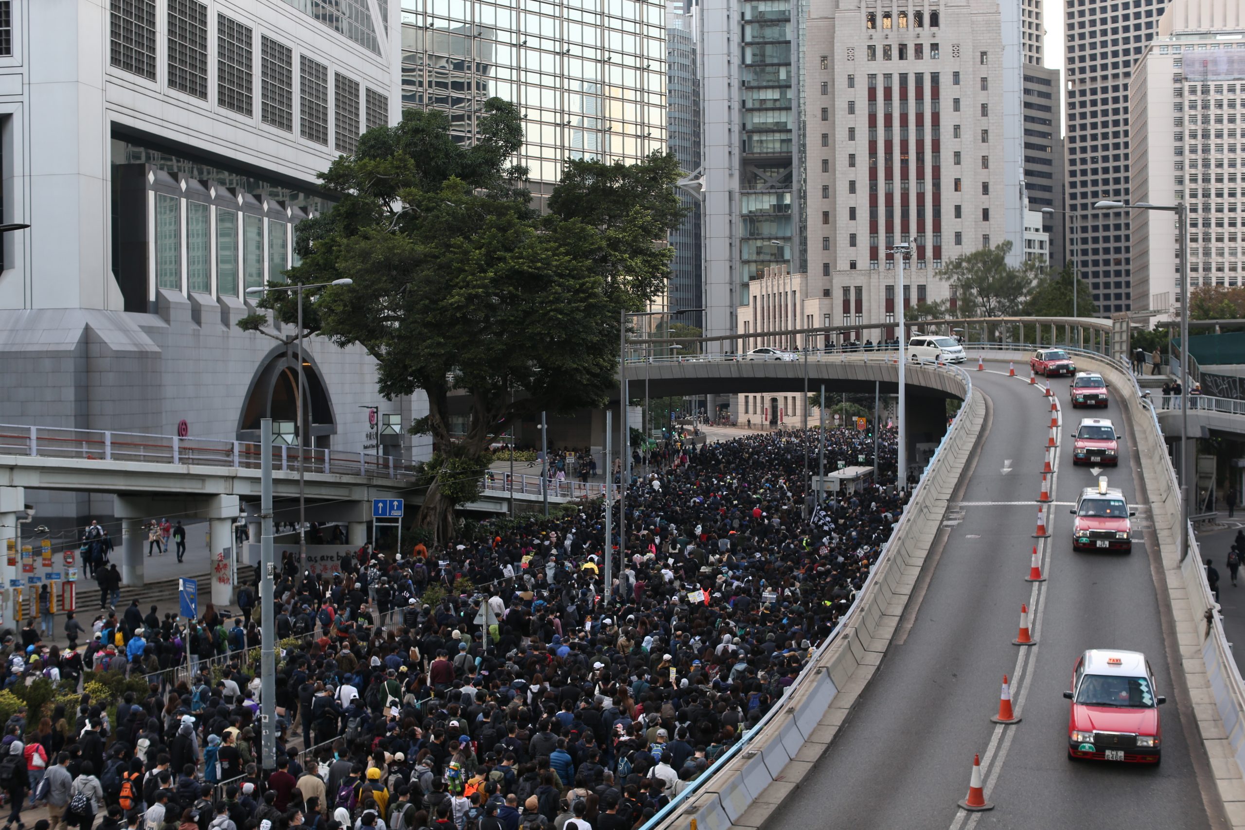 epa08054232 Cars drive by as Hong Kong's pro-democracy protesters (L) take part in a rally organized by the Civil Human Rights Front ahead of the upcoming Human Rights Day, in Hong Kong, China, 08 December 2019. Human Rights Day is celebrated annually across the world on 10 December. Hong Kong is in its sixth month of mass protests, which were originally triggered by a now withdrawn extradition bill, and have since turned into a wider pro-democracy movement.  EPA/JEROME FAVRE