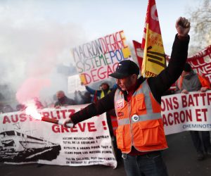 epa08059975 A protestor lights a flare as he participates in a demonstration against pension reforms in Paris, France, 10 December 2019. French unions representing railway and transport workers and many others in the public sector called for a general strike and demonstrations to protest against the French government's reform of the pension system which is planned to be announced on 11 December.  EPA/IAN LANGSDON