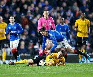 epa08067121 Referee Felix Brych (C) gives a yellow card to Ryan Jack (L) of Rangers after this challenge on Young Boys' Michel Aebischer (ground)  during the UEFA Europa League match Rangers v BSC Young Boys in Glasgow, Britain, 12 December 2019.  EPA/ROBERT PERRY