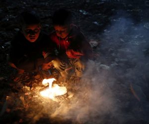 epa08083852 Bangladesh children to keep warm themselves by setting rubbish on fire at night during a cold wave grips in Dhaka, Bangladesh 20 December 2019. According to the Met office a mild cold wave sweeping across the county in Bangladesh.  EPA/MONIRUL ALAM