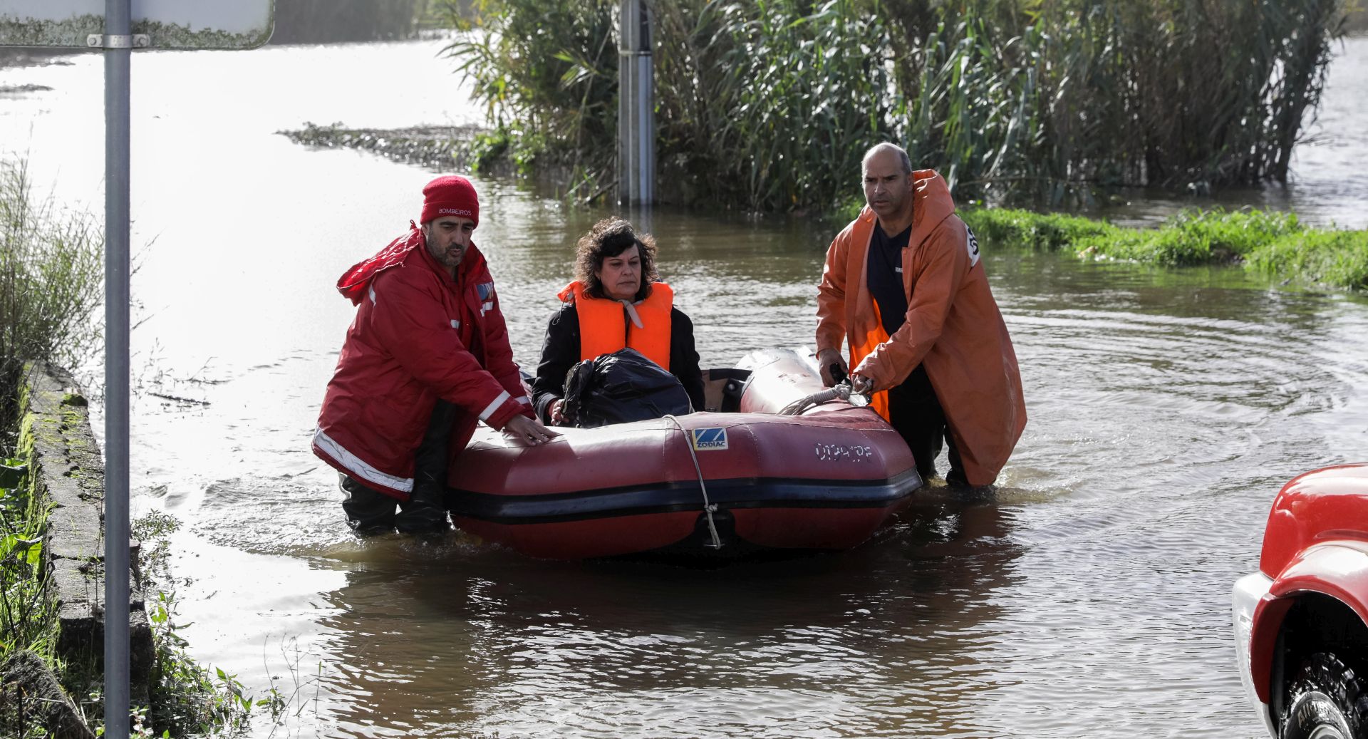 epa08085455 Firefighters on a boat help people get out of flooded and isolated houses due to rising water from the Mondego and Ega rivers in Formoselha, caused by rain and bad weather, in Coimbra, Portugal, 21 December 2019.  EPA/PAULO NOVAIS