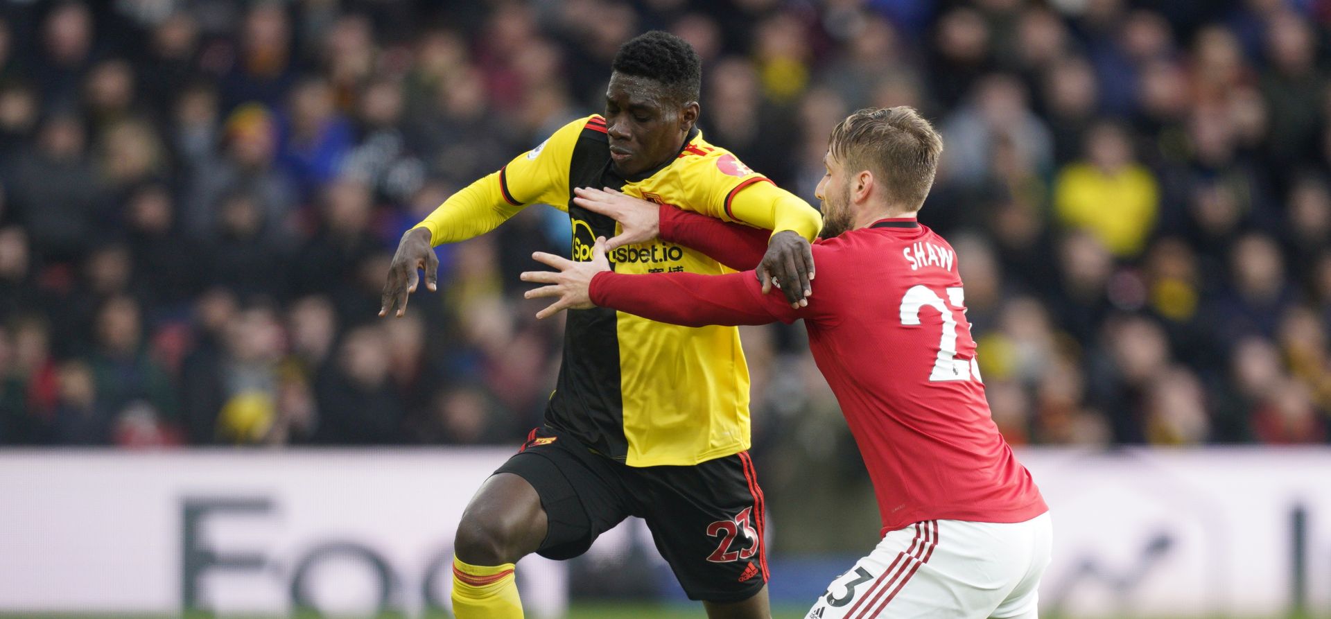 epa08086871 Watford's Ismaila Sarr (L) vies for the ball against Manchester United's Luke Shaw (R) during the English Premier League soccer match between Watford and Manchester United at Vicarage Road Stadium, London Britain, 22 December 2019.  EPA/WILL OLIVER EDITORIAL USE ONLY. No use with unauthorized audio, video, data, fixture lists, club/league logos or 'live' services. Online in-match use limited to 120 images, no video emulation. No use in betting, games or single club/league/player publications