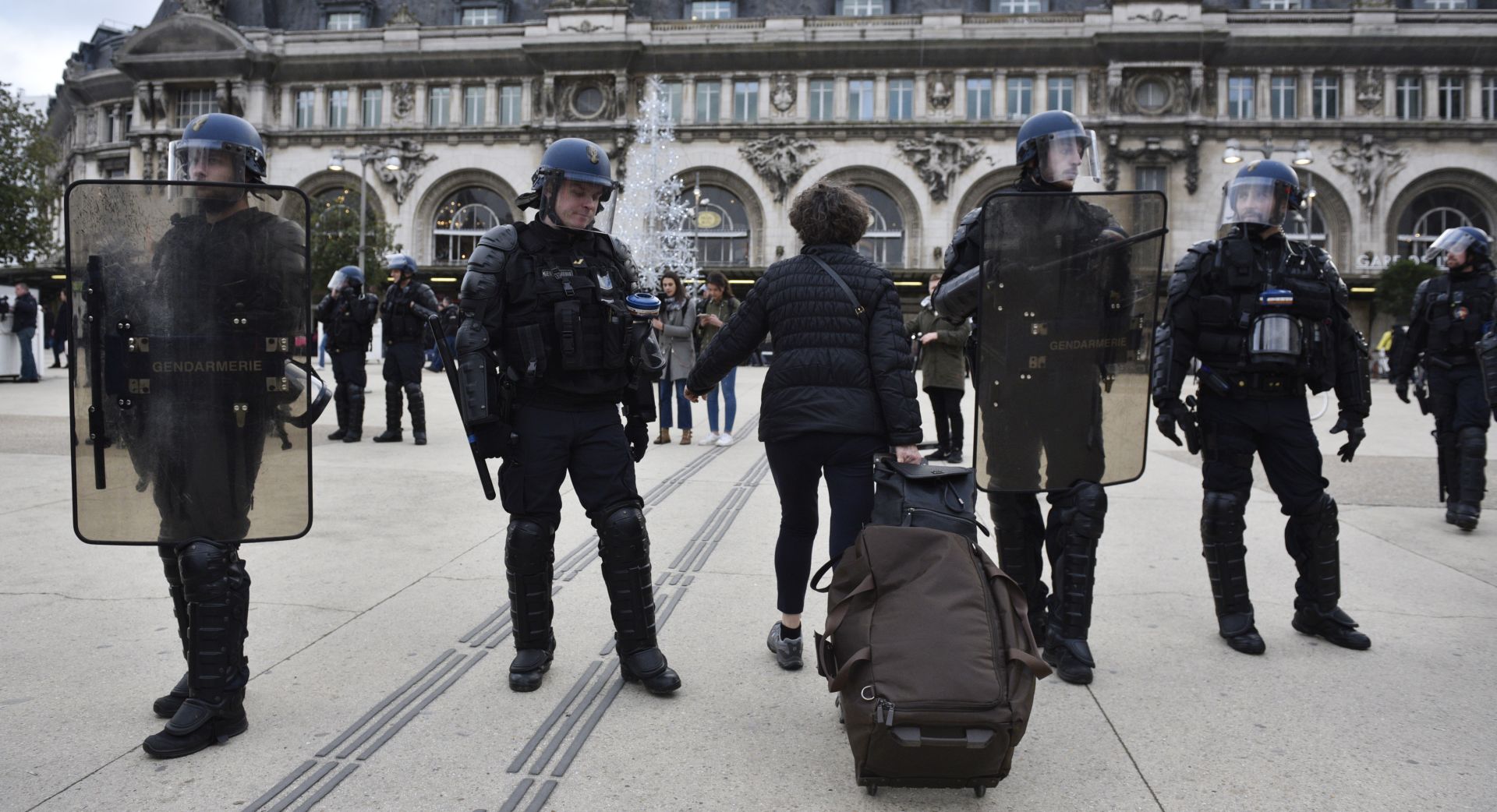epa08088258 French riot police help travelers during a demonstration against pension reforms on the Gare de Lyon train station in Paris, France, 23 December 2019. Unions representing railway and transport workers and many others in the public sector have called for a general strike and demonstration to protest against French government's reform of the pension system.  EPA/Julien de Rosa