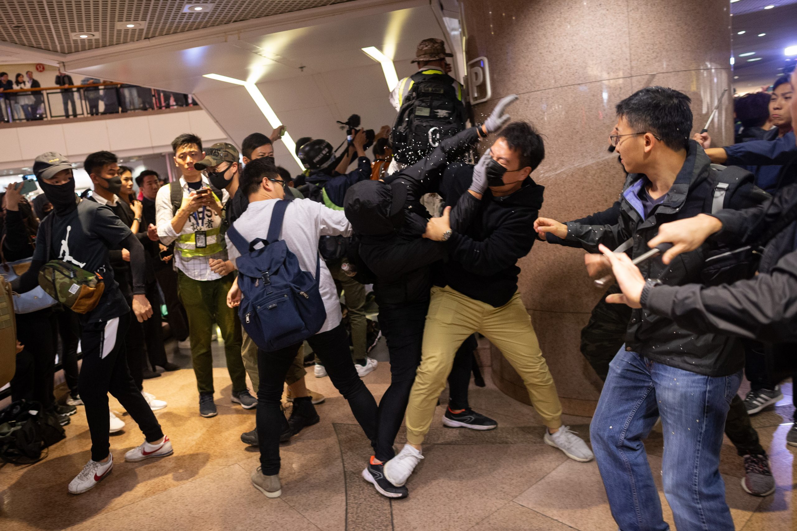 epa08089167 Plain cloth police officers clash with pro-democracy protesters in a shopping mall in Hong Kong, China, 24 December 2019. Police fired multiple rounds of tear gas in the tourist district of Tsim Sha Tsui on Christmas eve, after clashes broke out inside a shopping mall as a large number of protesters join a 'Christmas shopping' rally. Hong Kong has entered its seventh month of mass protests, which were originally triggered by a now withdrawn extradition bill, and have since turned into a wider pro-democracy movement.  EPA/JEROME FAVRE