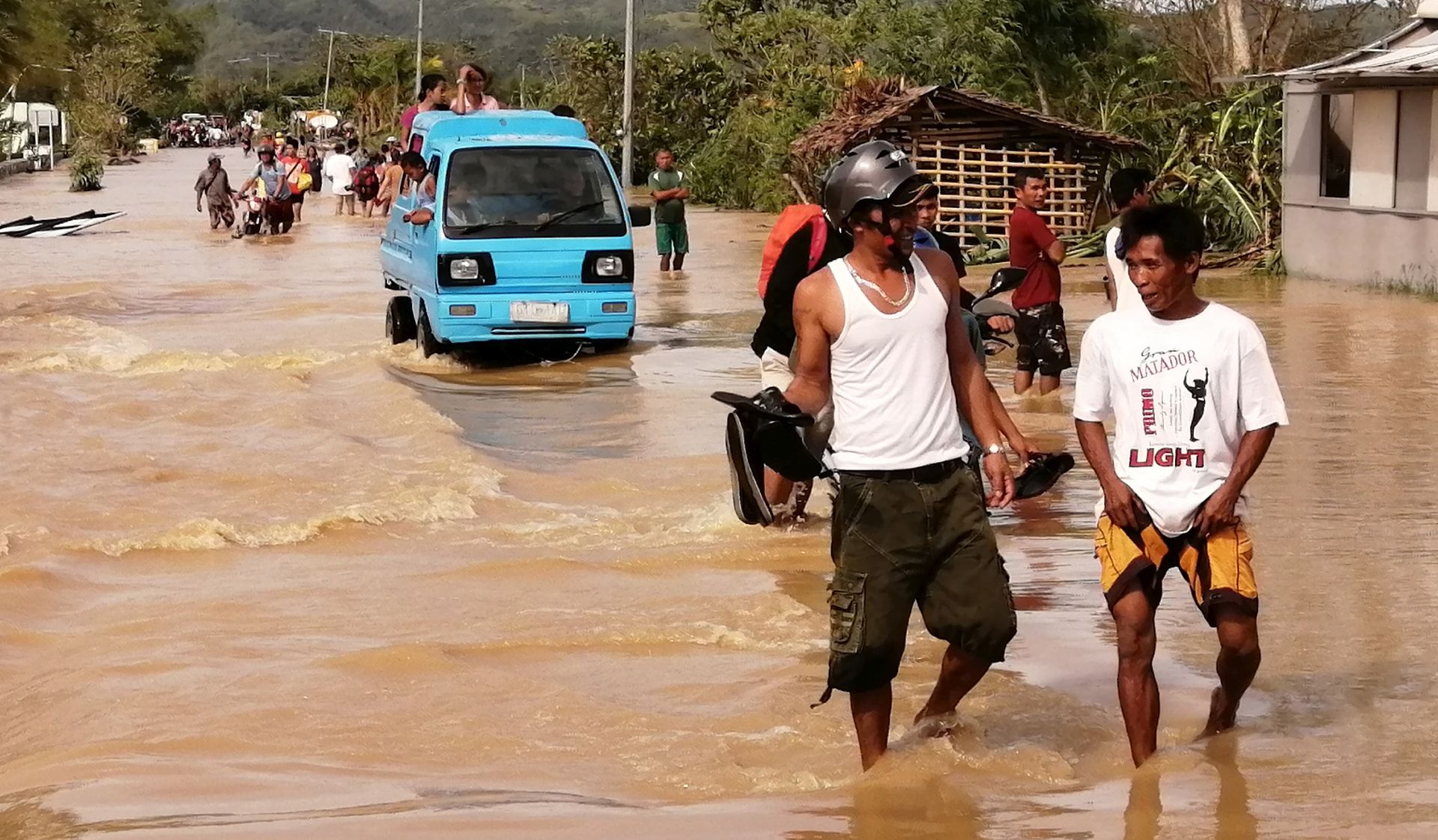 epa08089576 Motorists wade through water on a flooded road on Christmas day in the typhoon-hit city of Ormoc, Philippines, 25 December 2019. Typhoon Phanfone, (locally known as Ursula), made landfall in the Philippines with sustained winds of up to 150 kilometers per hour and caused cancellation at airports, seaports, and bus stations, affecting thousands of travelers on Christmas eve. Christmas is one of the busiest times of the year in the country, an archipelago made up of more than 7,000 islands with a population that is mostly Catholic.  EPA/ROBERT DEJON