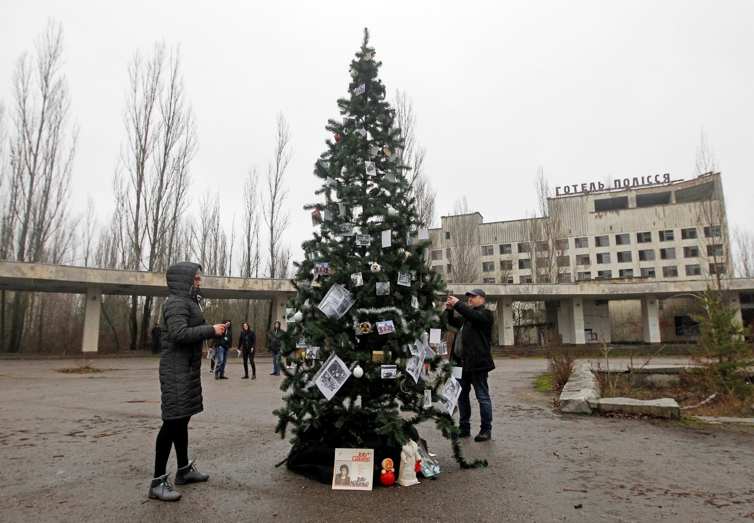 epa08090044 A Christmas tree with photos of former residents is installed on a central square of the abandoned city of Pripyat, not far from the Chernobyl nuclear power station, Ukraine, 25 December 2019. For the first time in 33 years, the Christmas tree was set up in Pripyat at the Chornobyl Exclusion Zone. Eighteen former residents of Pripyat who had not been in their hometown for many years decorated the Cristmass tree with their family photos taken in Pripyat when the city was not yet evicted. In the early hours of 26 April 1986 the Unit 4 reactor at the Chernobyl power station blew apart. Facing nuclear disaster on unprecedented scale, Soviet authorities tried to contain the situation by sending thousands of ill-equipped men into a radioactive maelstrom. The explosion of Unit 4 of the Chernobyl nuclear power plant is still regarded the biggest accident in the history of nuclear power generation.  EPA/STEPAN FRANKO