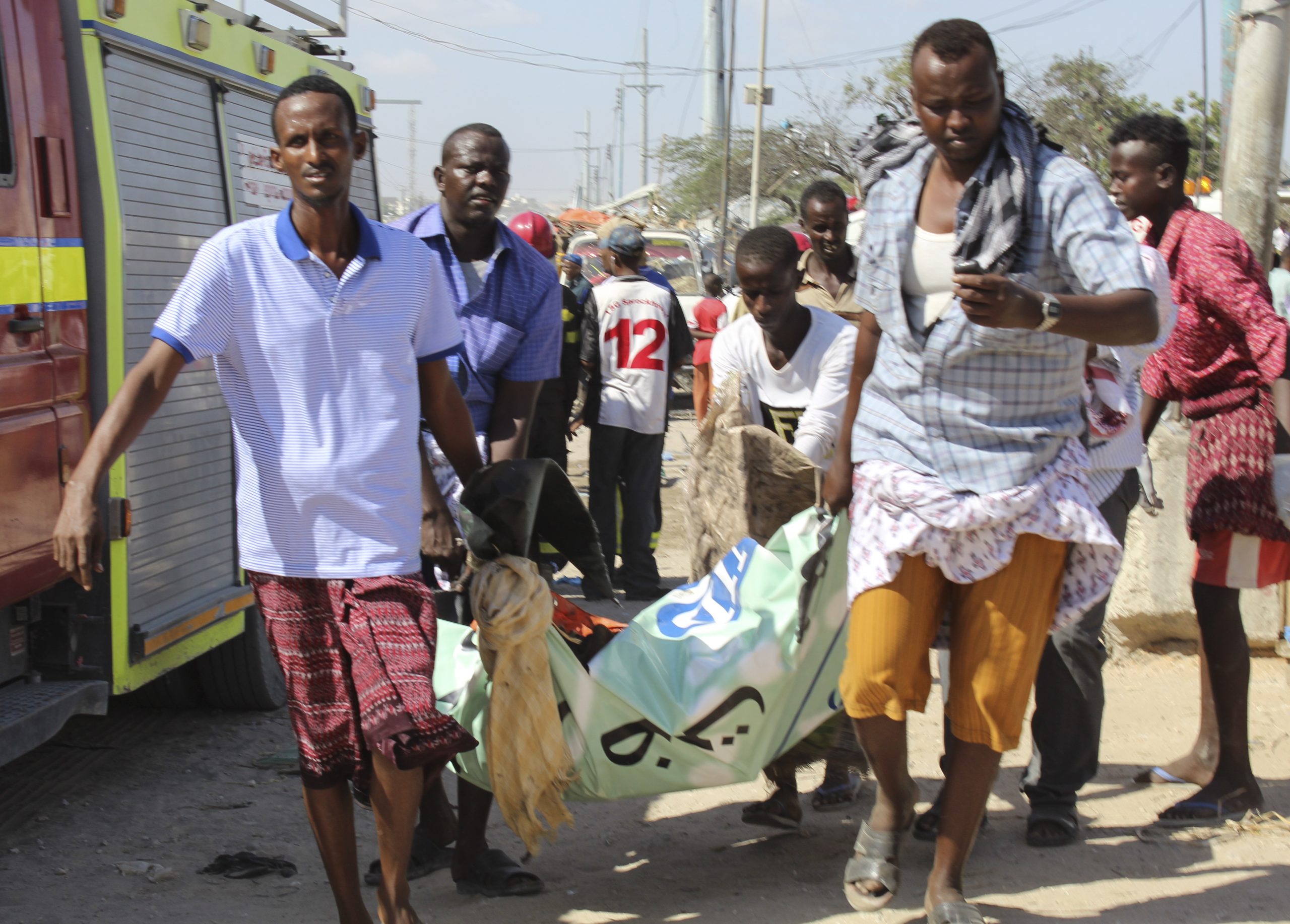epa08092427 An injured person is carried away from the scene of a large explosion near a check point in Mogadishu, Somalia, 28 December 2019. A source at a hospital said that the death toll has risen to at least 76 in what is believed to have been a car bombing. The explosion rocked an area near the junction called Ex-Control Afgoye, in a southwestern suburb of the capital Mogadishu.  EPA/SAID YUSUF WARSAME