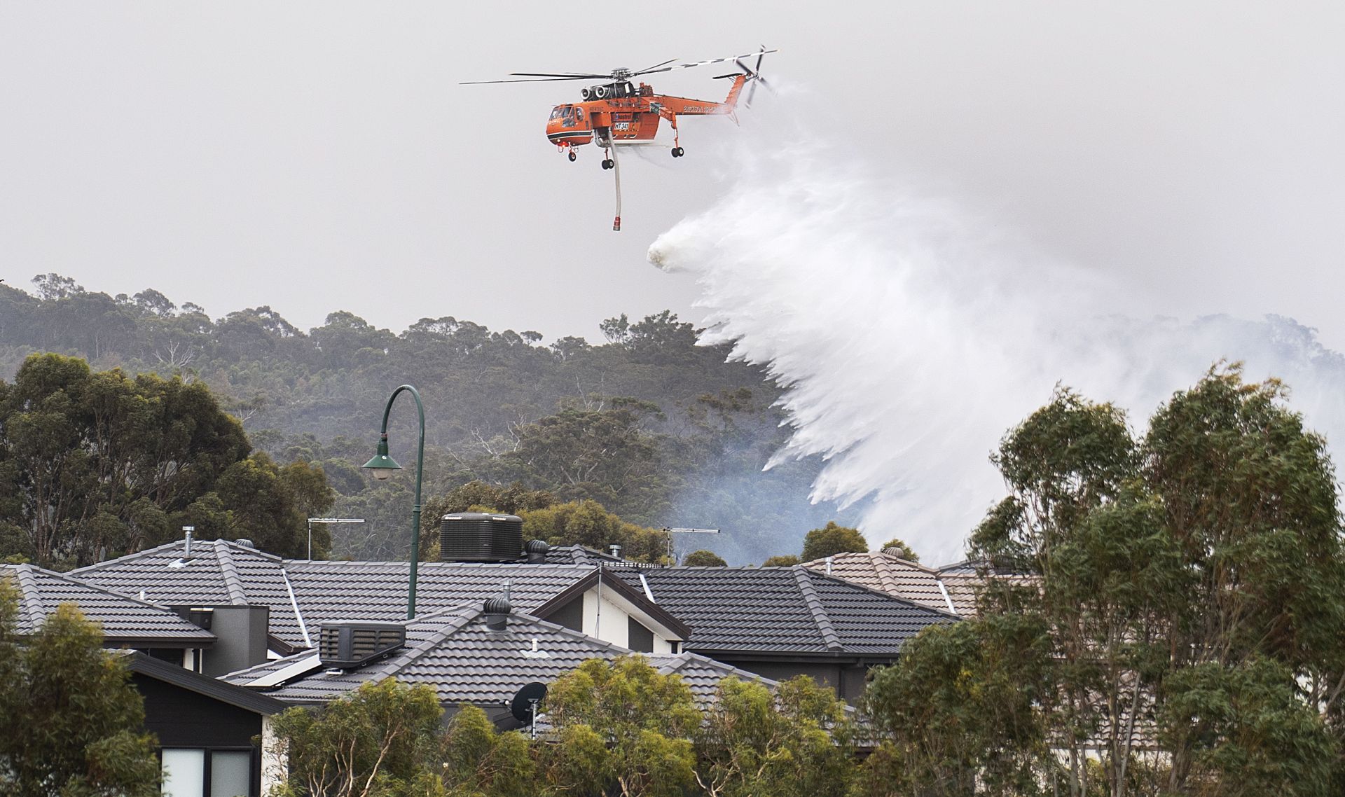 epaselect epa08094624 A Skycrane drops water on a bushfire in Bundoora, Melbourne, Australia, 30 December 2019. According to local media reports, thousands of residents and tourists were forced to evacuate in the state of Victoria as soaring temperatures and winds fanned several bushfires around the state.  EPA/ELLEN SMITH AUSTRALIA AND NEW ZEALAND OUT