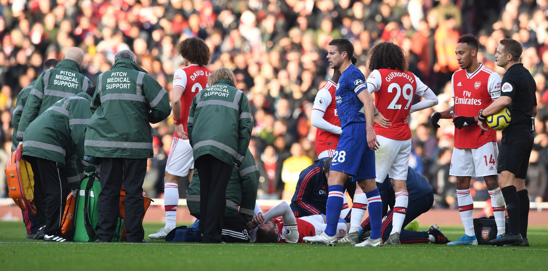epa08093779 Arsenal's Calum Chambers (C, down) reacts in pain during the English Premier League soccer match between Arsenal FC and Chelsea FC held at the Emirates stadium in London, Britain, 29 December 2019.  EPA/NEIL HALL EDITORIAL USE ONLY.  No use with unauthorized audio, video, data, fixture lists, club/league logos or 'live' services. Online in-match use limited to 120 images, no video emulation. No use in betting, games or single club/league/player publications.