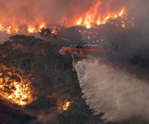epa08095696 A handout photo made available by the State Government of Victoria on 31 December 2019 shows a firefighting helicopter tackling a bushfire near Bairnsdale in Victoria's East Gippsland region, Australia.  EPA/STATE GOVERNMENT OF VICTORIA HANDOUT AUSTRALIA AND NEW ZEALAND OUT HANDOUT EDITORIAL USE ONLY/NO SALES