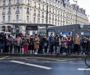 epa08098565 Commuters wait at a bus stop outside the Saint Lazare Suburban train station during a general strike action, in Paris, France, 02 January 2020. The ongoing general strike of the transport workers in the public sector against the French government's pension reform is on the 28th day and is now the longest of the Railway sector.  EPA/Christophe Petit Tesson