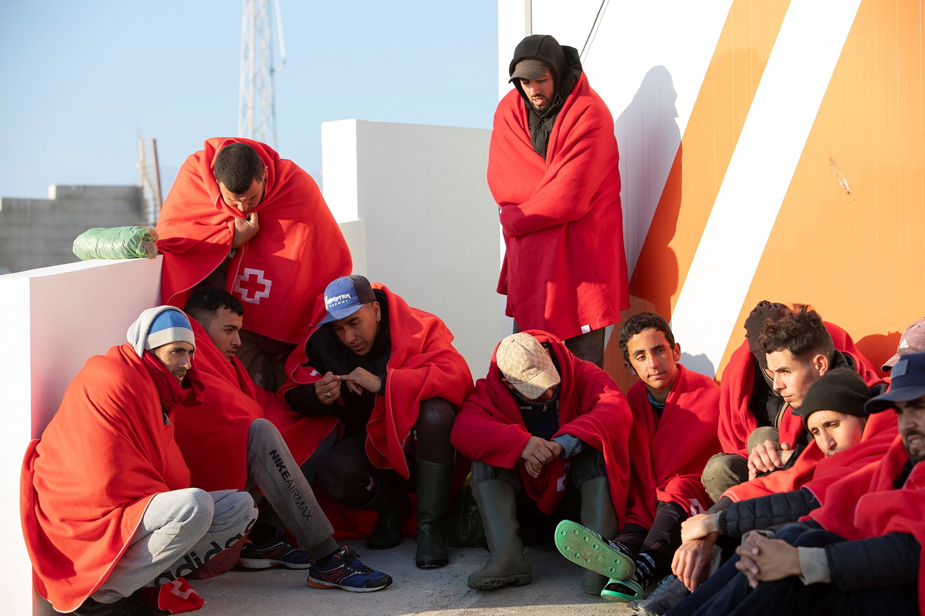 epa08099849 Several Maghrebi migrants rest upon their arrival at the port in Motril, southern Spain, 03 January 2020. Spanish authorities rescued a total of 17 Maghrebi migrants, including four minors, who were on board a boat off Spanish southern coast.  EPA/Miguel Paquet