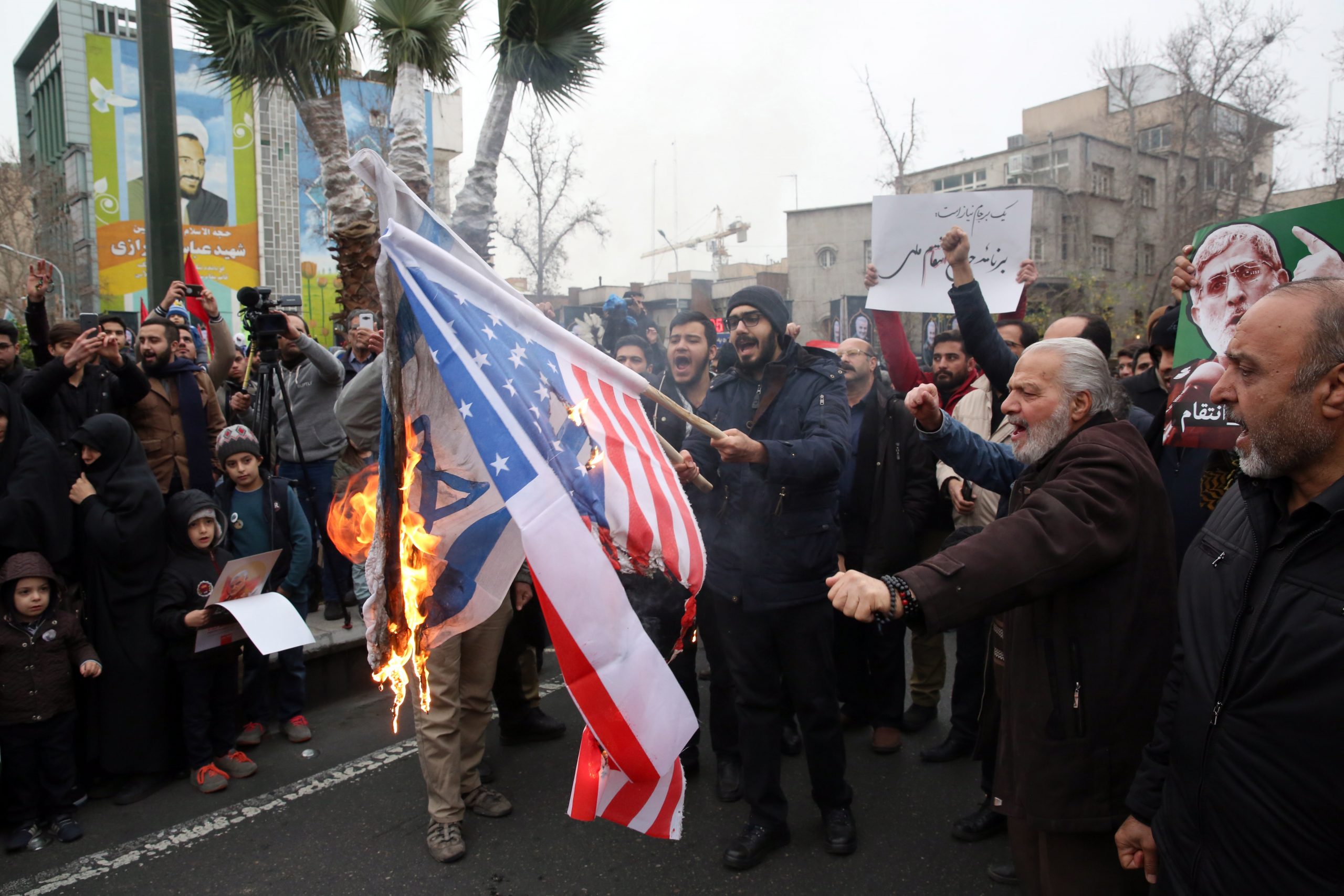 epa08102256 
Iranians burn US and Israel flags during anti-US protests over killing late Iranian Revolutionary Guards Corps (IRGC) Lieutenant general and commander of the Quds Force Qasem Soleimani  in Tehran, Iran, 04 January 2020. The Pentagon announced that Iran's Quds Force leader Qasem Soleimani and Iraqi militia commander Abu Mahdi al-Muhandis were killed on 03 January 2020 following a US airstrike at Baghdad's international airport. The attack comes amid escalating tensions between Tehran and Washington  EPA/ABEDIN TAHERKENAREH