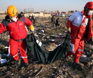 epaselect epa08111955 Members of the International Red Crescent collect bodies of victims around the wreckage after an Ukraine International Airlines Boeing 737-800 carrying 176 people crashed near Imam Khomeini Airport in Tehran, killing everyone on board, in Shahriar, Iran, 08 January 2020.  EPA/ABEDIN TAHERKENAREH