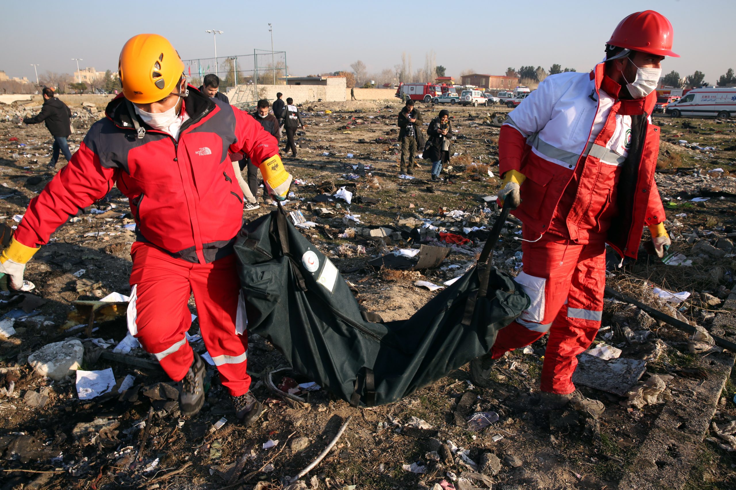 epaselect epa08111955 Members of the International Red Crescent collect bodies of victims around the wreckage after an Ukraine International Airlines Boeing 737-800 carrying 176 people crashed near Imam Khomeini Airport in Tehran, killing everyone on board, in Shahriar, Iran, 08 January 2020.  EPA/ABEDIN TAHERKENAREH