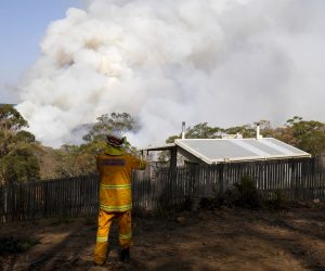 epa08116116 NSW Rural Fire Service crews watch on as a fire burns in bushland close to homes at Penrose in the NSW Southern Highlands, some 165km south of Sydney, New South Wales (NSW), Australia, 10 January 2020. The Rural Fire Service has placed total fire bans on 10 regions across the state.  EPA/DAN HIMBRECHTS  AUSTRALIA AND NEW ZEALAND OUT