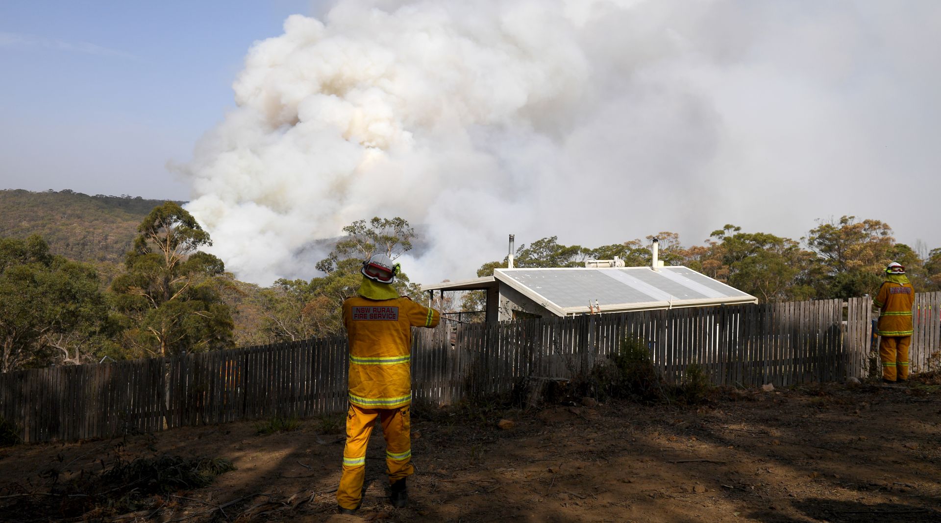 epa08116116 NSW Rural Fire Service crews watch on as a fire burns in bushland close to homes at Penrose in the NSW Southern Highlands, some 165km south of Sydney, New South Wales (NSW), Australia, 10 January 2020. The Rural Fire Service has placed total fire bans on 10 regions across the state.  EPA/DAN HIMBRECHTS  AUSTRALIA AND NEW ZEALAND OUT