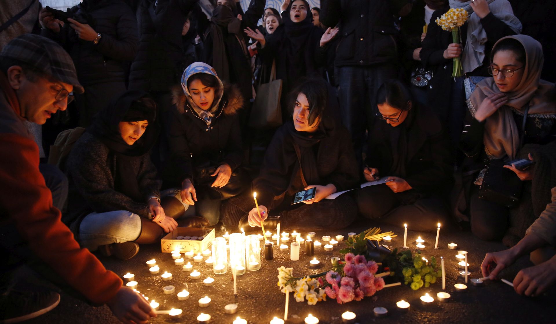 epa08119823 Iranians light candle for victims of Ukraine International Airlines Boeing 737-800 during as they protest in front of the Amir Kabir University in Tehran, Iran, 11 January 2020. Media reported that hundreds of Iranians protests in Tehran in solidarity with victims of the Ukraine plane as Iranian military released a statement claiming that Ukraine International Airlines flight PS752 was shot down due to human error.  EPA/ABEDIN TAHERKENAREH