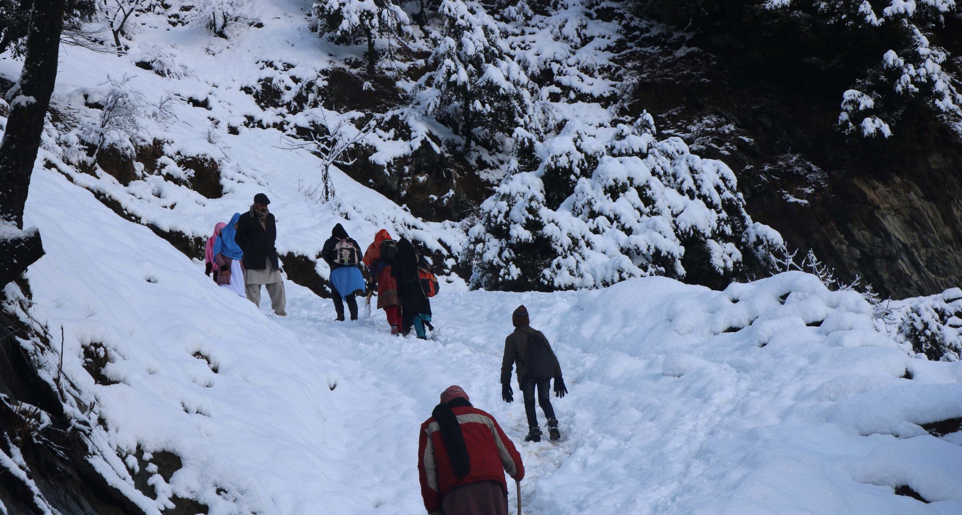 epa08126461 People walk on a snow-covered mountain path in Neelum valley, Pakistani administered Kashmir, 14 January 2020. At least 57 people were killed and several others were stranded when an avalanche hit villages in Neelum valley in Pakistani administered Kashmir. Many cities in Pakistan are experiencing unusual cold weather conditions during which regular daytime temperatures fall below zero degrees Celsius.  EPA/AMIRUDDIN MUGHAL