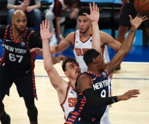 epa08134763 New York Knicks guard RJ Barrett (R) tries to put up a shot past a defending Phoenix Suns forward Dario Saric (C) of Croatia in the second half of the NBA basketball game between the Phoenix Suns and the New York Knicks at Madison Square Garden in New York, New York, USA, 16 January 2020.  EPA/JASON SZENES SHUTTERSTOCK OUT