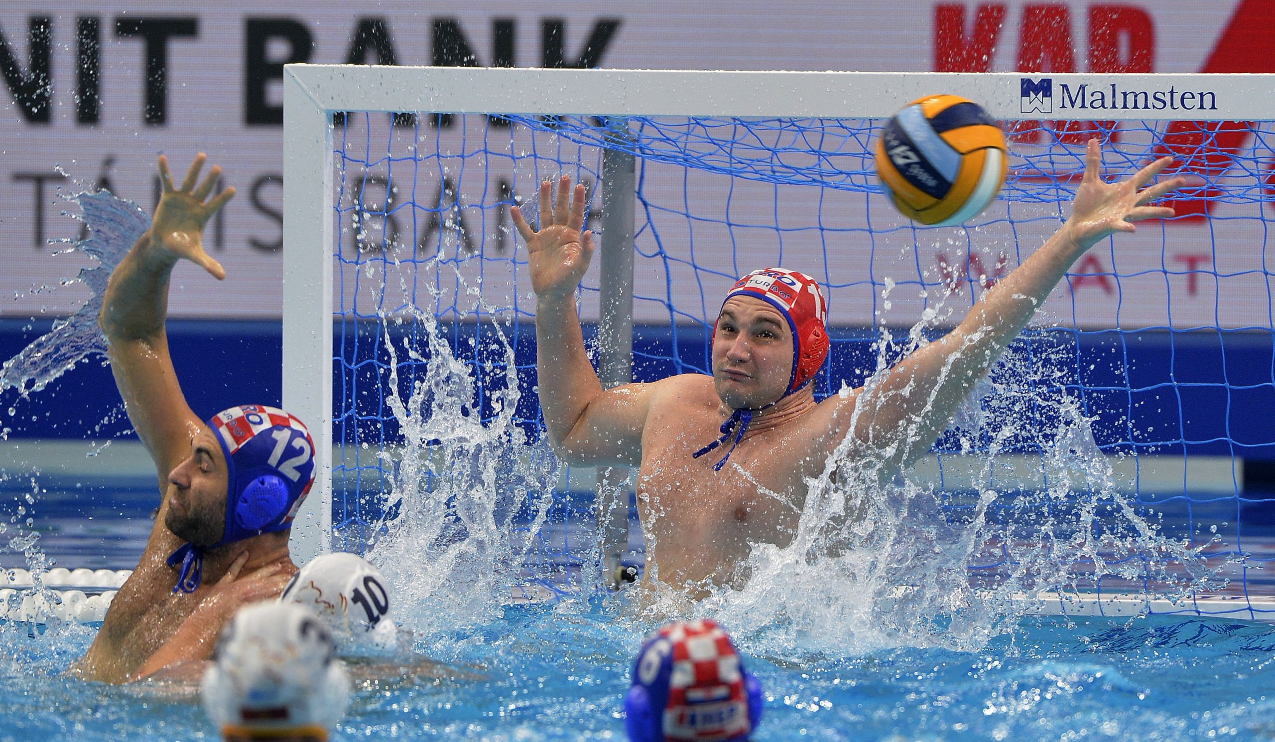 epa08167592 Goalie Ivan Marcelic (R) and Javier Garcia (L) of Croatia try to block a shot during men's European Water Polo Championship match Montenegro vs. Croatia for the bronze medal in Budapest, Hungary, 26 January 2020.  EPA/Balazs Czagany HUNGARY OUT