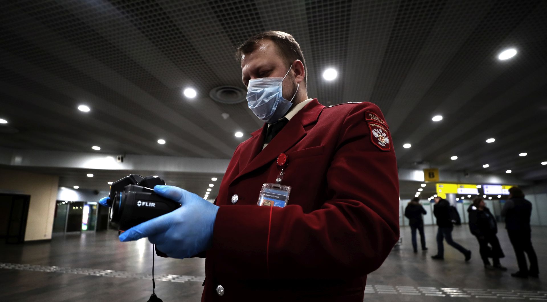 epa08178132 An official of Russian Quarantine Service of Rospotrebnadzor (Federal Service for the Oversight of Consumer Protection and Welfare) uses thermal imaging devices to remotely measure temperature of passengers at the Sheremetyevo airport in Moscow, Russia, 30 January 2020. The outbreak of coronavirus has so far claimed 170 lives and infected more than 8,000 others, according to media reports. 
Russian health and immigration officials have taken action to screen those arriving at the country from China over the virus fears.  EPA/MAXIM SHIPENKOV
