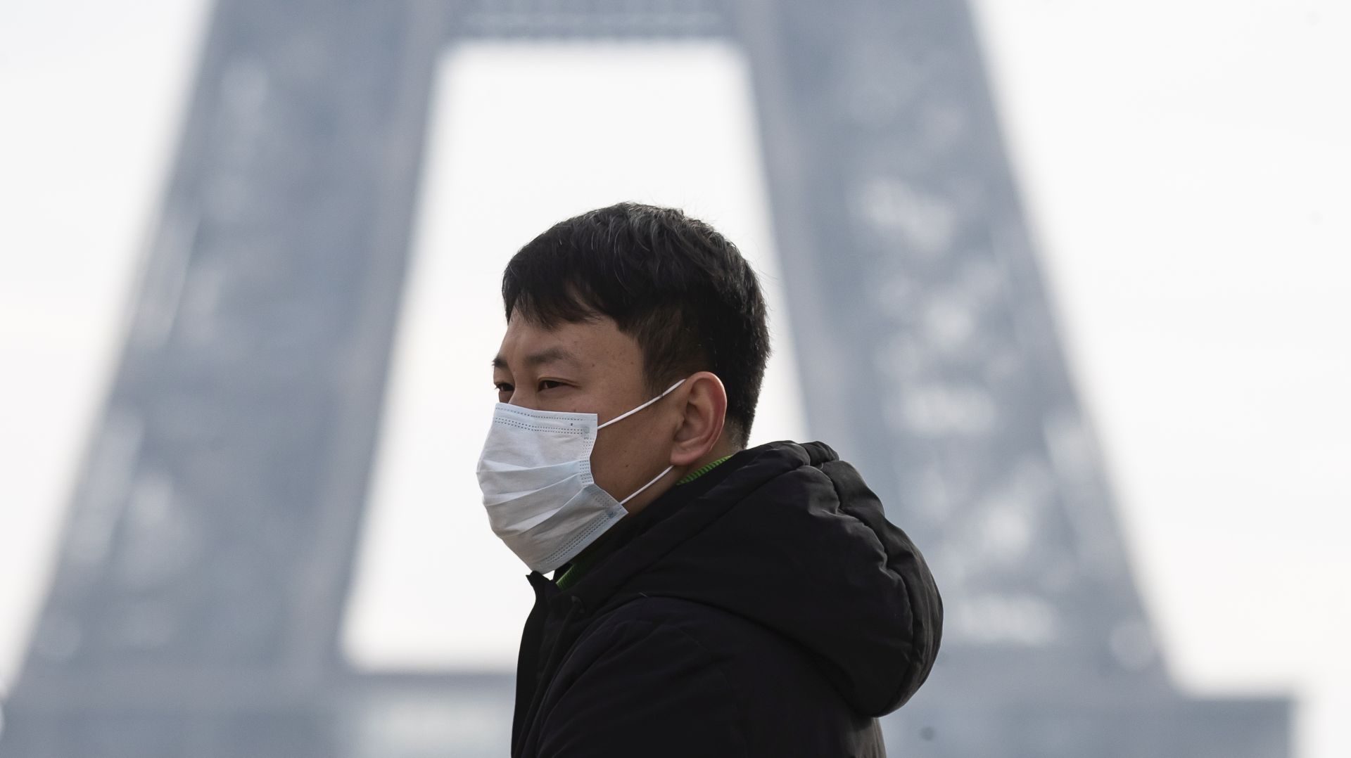 epa08219872 (FILE) - A tourist wears a face mask near the Eiffel Tower in Paris, France, 25 January 2020 (reissued 15 February 2020). The French Ministry of Health announced on 15 February that an 80-year-old Chinese tourist from Hubei province, who was hospitalized in intensive care at Bichat hospital in Paris in late January, had died from the novel coronavirus, marking the first death outside Asia of the virus.  EPA/IAN LANGSDON