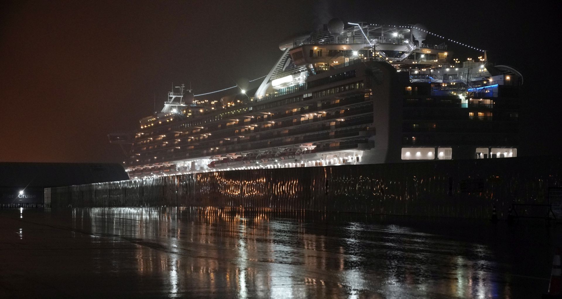 epa08223407 The Diamond Princess cruise ship is seen docked under heavy rain at the Daikoku Pier Cruise Terminal in Yokohama, south of Tokyo, Japan, 16 February 2020 (issued 17 February 2020). According to latest media reports on 17 February, another 99 passengers of the Diamond Princess cruise ship have been tested positive for the Covid-19 coronavirus, rising the total number of infections to 454 in the vessel.  EPA/FRANCK ROBICHON