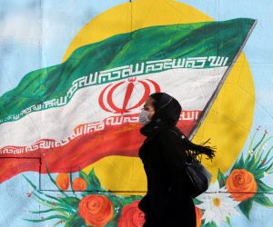 epa08228565 (FILE) - An Iranian woman wearing a mask walks next to a wall painting of Iranian national flag in Tehran, Iran, 12 February 2020 (reissued 19 February 2020). According to the Ministry of Health, two people diagnosed with coronavirus died in the city of Qom, central Iran.  EPA/ABEDIN TAHERKENAREH