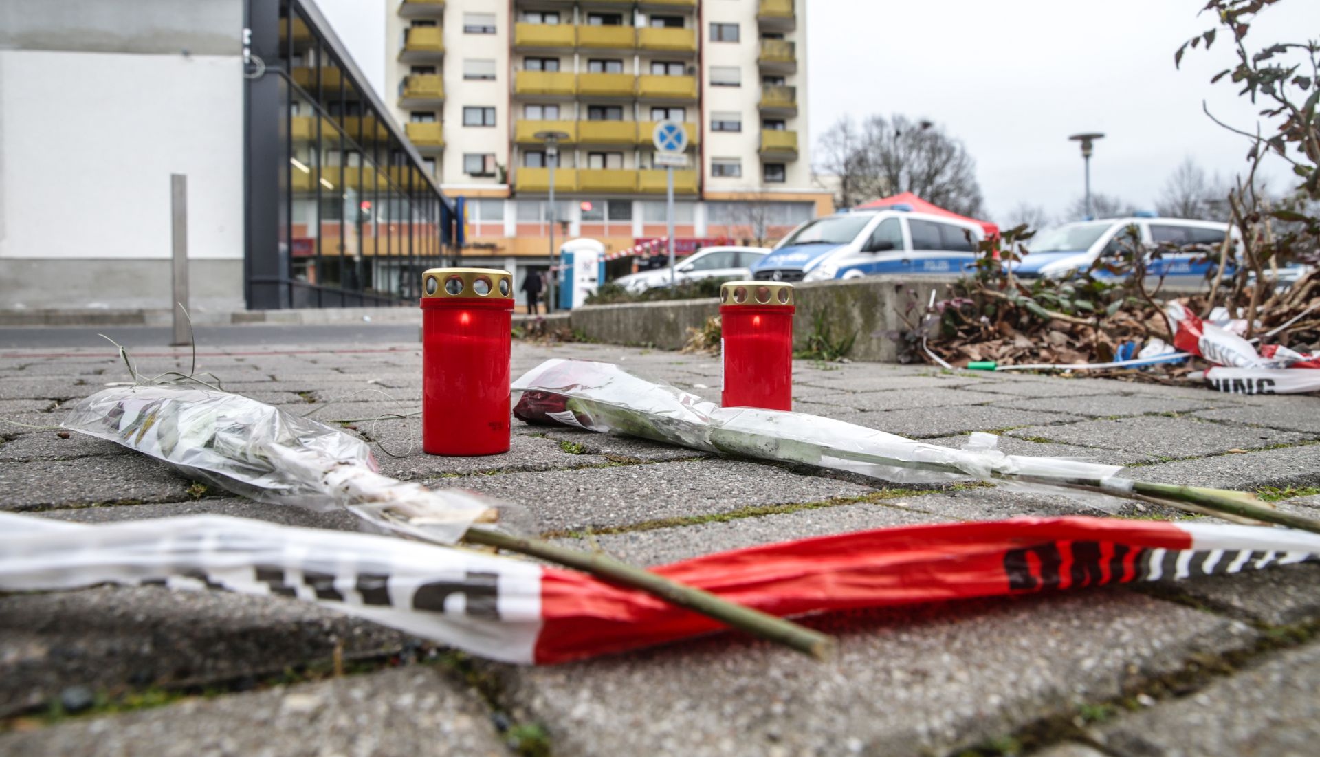 epa08229796 Flowers and candles are placed near a crime scene were five people shoot dead, after two shootings in Hanau, Germany, 20 February 2020. According to media reports, at least nine people were killed in two shootings at shisha bars in the western German city of Hanau, on the outskirts of Frankfurt on 19 February 2020.  EPA/ARMANDO BABANI