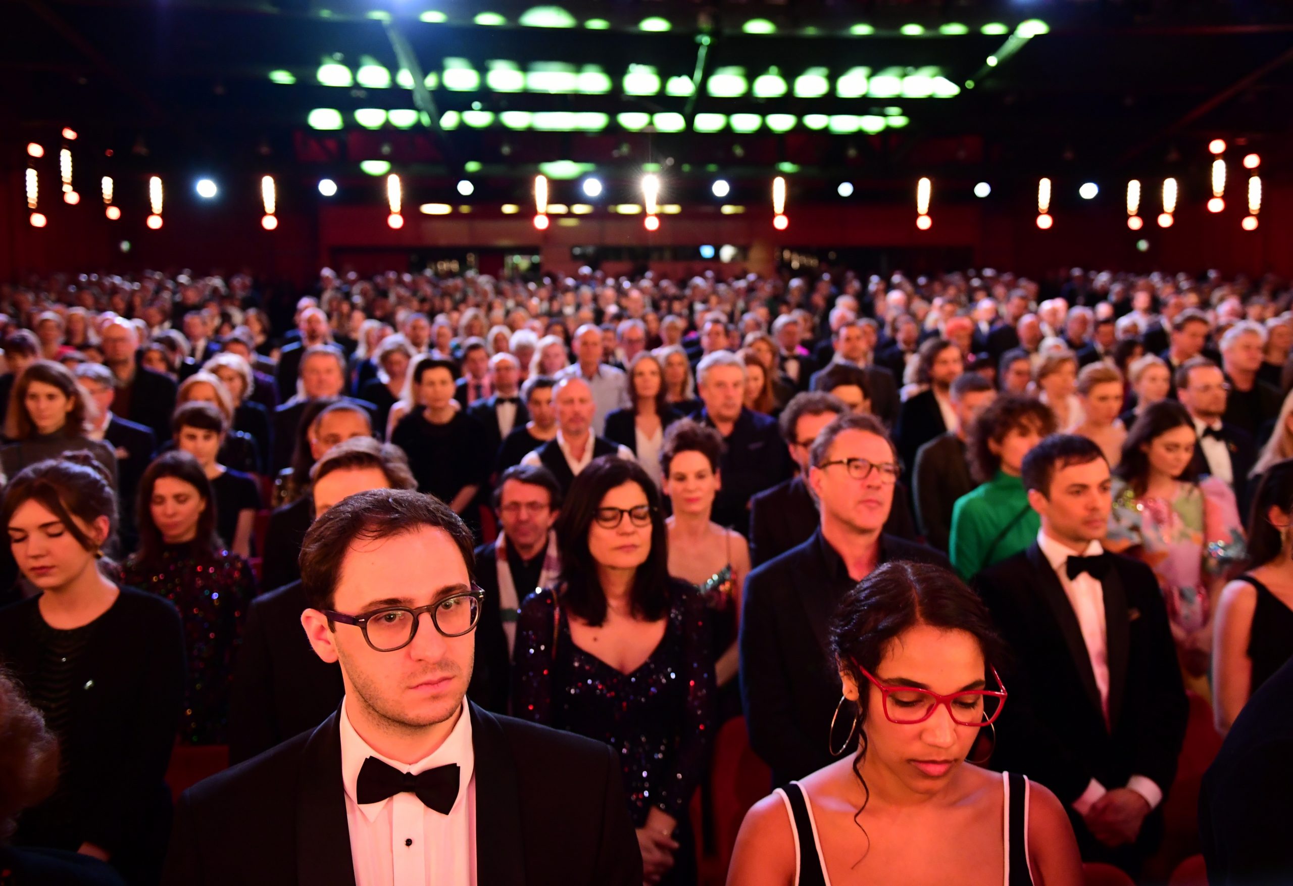 epa08232176 Members of the audience observe a minute of silence for the victims of the Hanau shootings during the Opening Ceremony of the 70th annual Berlin International Film Festival (Berlinale), in Berlin, Germany, 20 February 2020. The Berlinale runs from 20 February to 01 March 2020.  EPA/CLEMENS BILAN