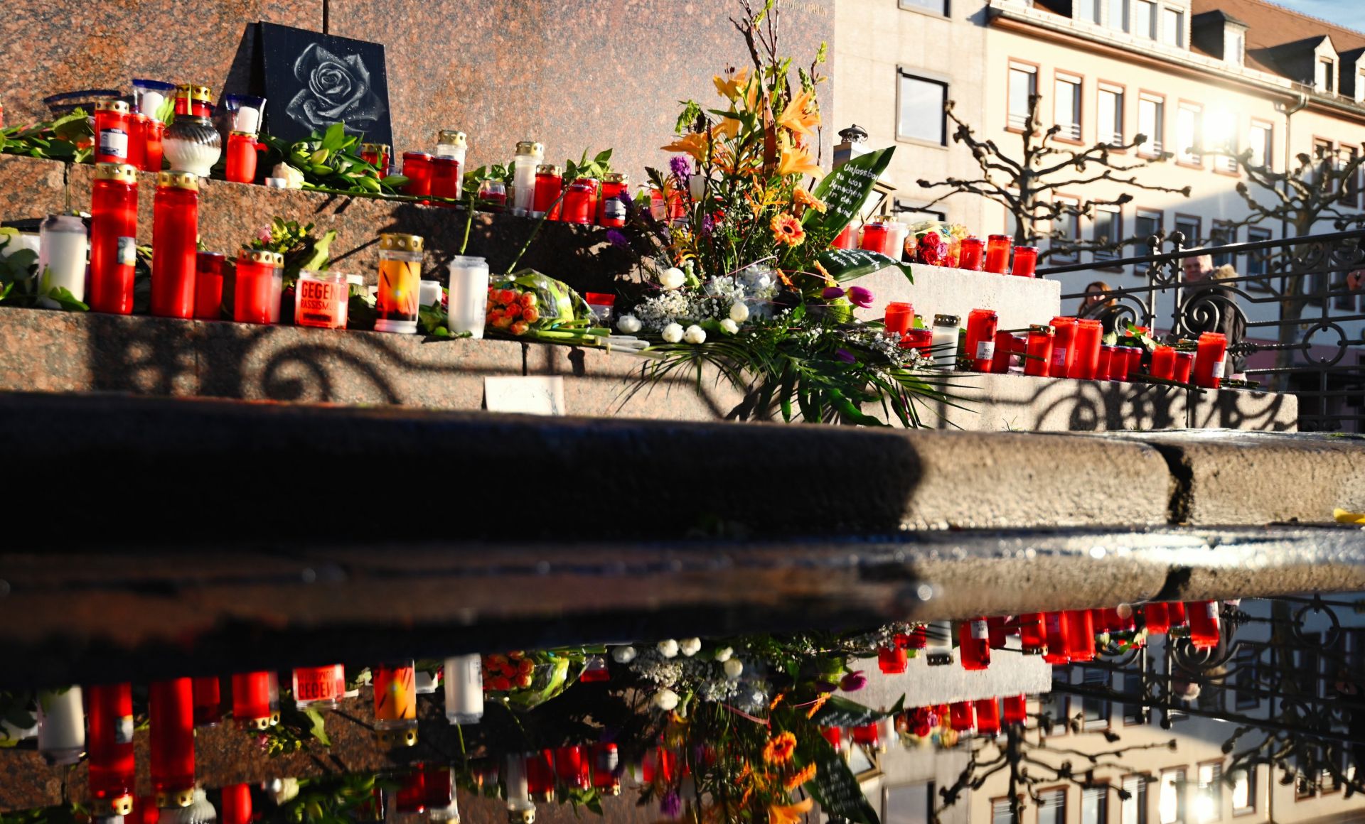 21 February 2020, Hessen, Hanau: Flowers and candles are placed near one of the two shisha bars after the shooting in Hanau. Nine people of foreign descent were killed in a pair of attacks before the alleged shooter returned to his home and killed himself and his 72-year-old mother. Photo: Nicolas Armer/dpa