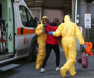 epa08252377 Health workers wearing full-body suits escort a person with a child in her arms (C) out of an ambulance, outside the Padua hospital, northern Italy, 27 February 2020. The number of people infected with the novel coronavirus (Covid-19) disease who have died in Italy has risen to 14, as the number of infected cases reached 528, Head of the Italian Civil Protection Borrelli said on the day.  EPA/NICOLA FOSSELLA -- ATTENTION EDITORS: IMAGE PIXELATED AT SOURCE IN ACCORDANCE WITH ITALIAN LAW