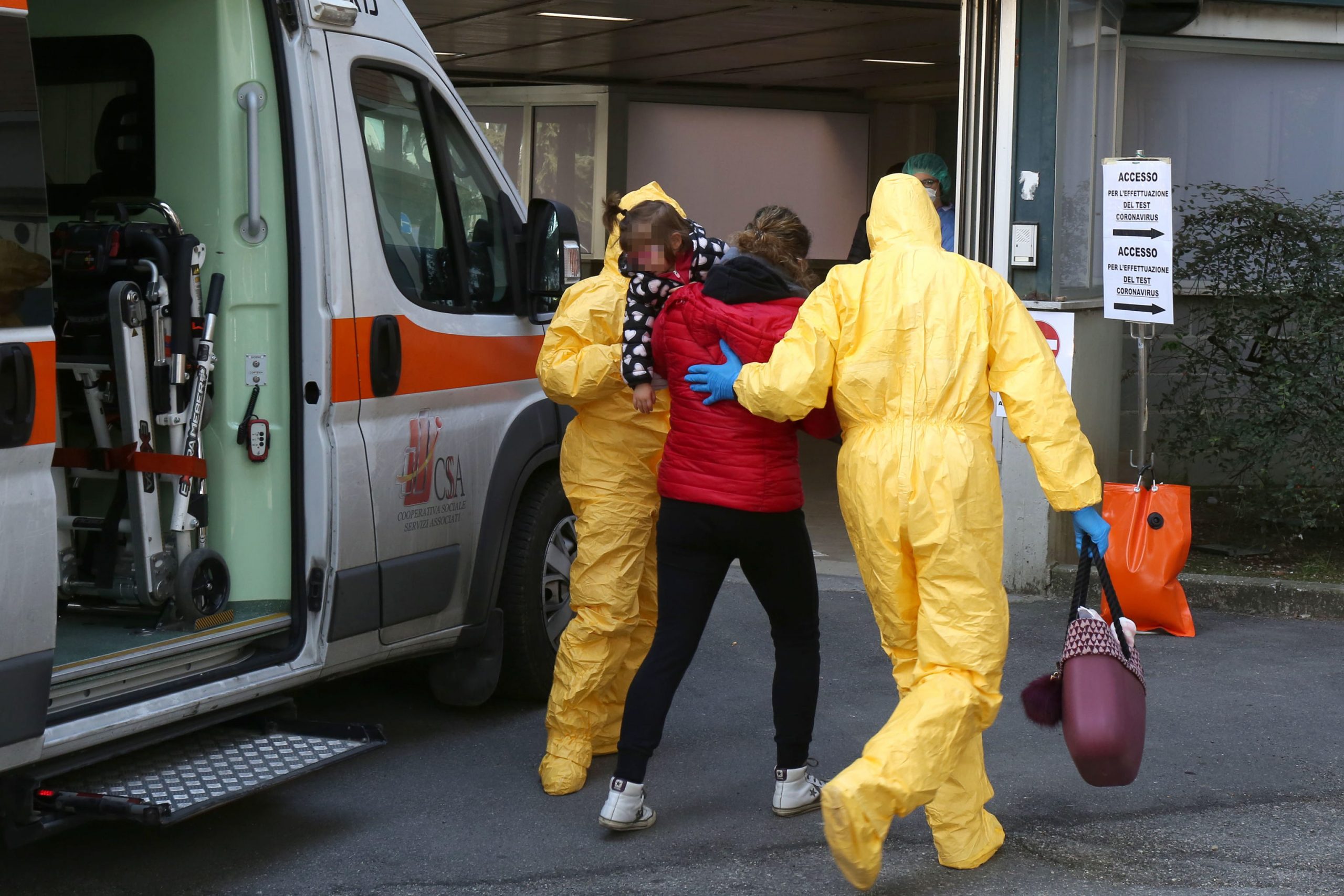 epa08252377 Health workers wearing full-body suits escort a person with a child in her arms (C) out of an ambulance, outside the Padua hospital, northern Italy, 27 February 2020. The number of people infected with the novel coronavirus (Covid-19) disease who have died in Italy has risen to 14, as the number of infected cases reached 528, Head of the Italian Civil Protection Borrelli said on the day.  EPA/NICOLA FOSSELLA -- ATTENTION EDITORS: IMAGE PIXELATED AT SOURCE IN ACCORDANCE WITH ITALIAN LAW