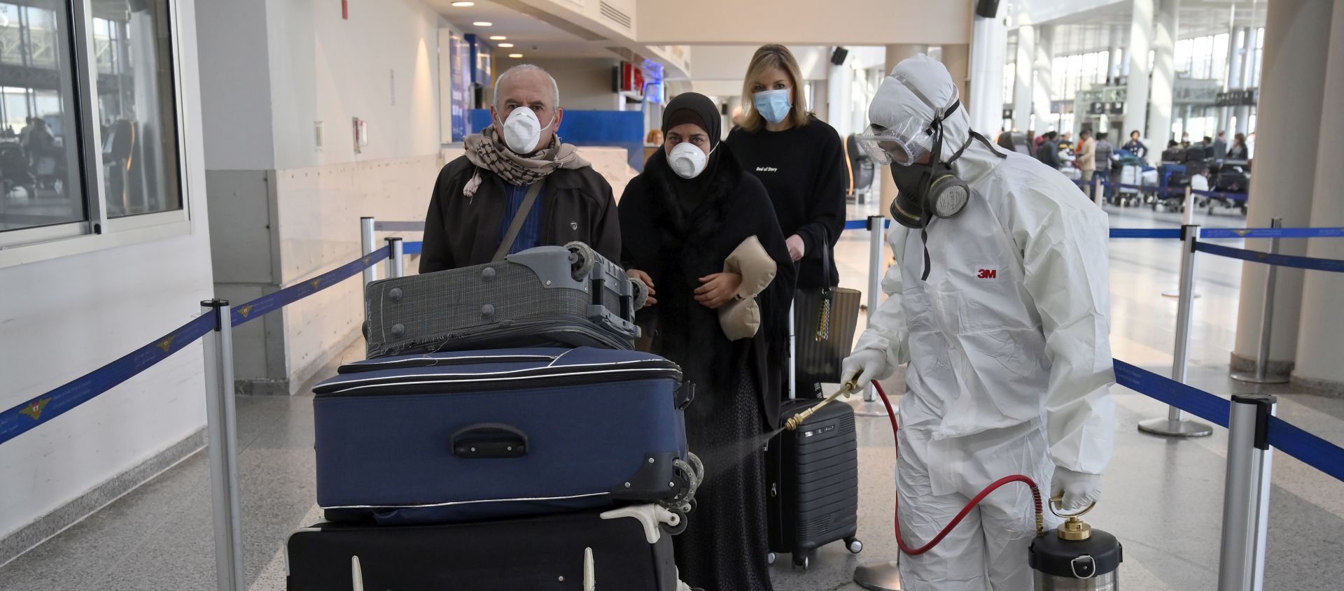 epa08271483 A worker wearing a protective suit sprays disinfectant as a precaution against the spread of the Covid-19 Coronavirus at Rafik Hariri international airport in Beirut, Lebanon, 05 March 2020. According to media reports, two new cases of coronavirus were confirmed on 04 March by a Health Ministry source, bringing the total number of those who have been infected in Lebanon to 15 cases.  EPA/WAEL HAMZEH