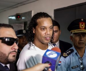 epa08275164 Ronaldo de Assis Moreira, a.k.a. Ronaldinho (C), arrives at the Palace of Justice to appear before Judge Mirko Valinotti, in Asuncion, Paraguay, 06 March 2020. Brazil's former international Ronaldinho Gaucho and his brother Roberto appeared on 06 March before the judge that will decide if they benefit from a procedural exit that separates them from the open cause after entering Paraguay with false passports. The appeal to this 'abbreviated procedural exit' was granted on 05 March by the Prosecutor's Office to the two brothers and it was because both contributed 'relevant data' to the investigation, as explained by the prosecutor of the case, Federico Delfino.  EPA/NATHALIA AGUILAR