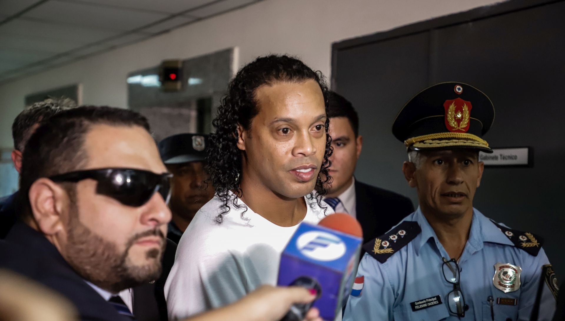 epa08275164 Ronaldo de Assis Moreira, a.k.a. Ronaldinho (C), arrives at the Palace of Justice to appear before Judge Mirko Valinotti, in Asuncion, Paraguay, 06 March 2020. Brazil's former international Ronaldinho Gaucho and his brother Roberto appeared on 06 March before the judge that will decide if they benefit from a procedural exit that separates them from the open cause after entering Paraguay with false passports. The appeal to this 'abbreviated procedural exit' was granted on 05 March by the Prosecutor's Office to the two brothers and it was because both contributed 'relevant data' to the investigation, as explained by the prosecutor of the case, Federico Delfino.  EPA/NATHALIA AGUILAR