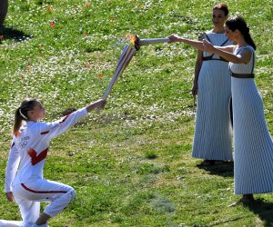 epa08289066 Greek torchbearer Anna Korakaki (L), 2016 Olympic gold medallist in 25m pistol, receives the Olympic flame from Greek actress Xanthi Georgiou (R) in the role of the High Priestess during the Lighting Ceremony​ of the Olympic Flame for the Tokyo Summer Olympics, in front of Hera Temple in Ancient Olympia, Greece, on 12 March 2020.  EPA/VASSILIS PSOMAS