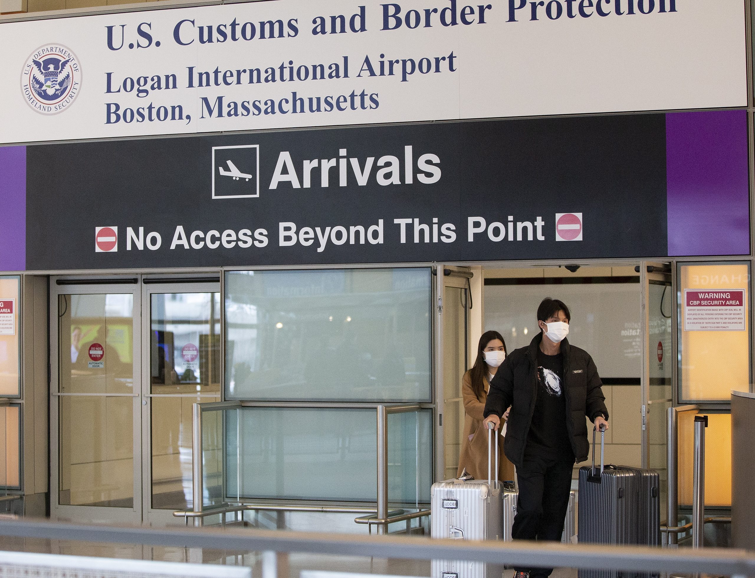 epa08290212 Passengers pass through the US Customs and Border Protection doorways on their arrival to Boston's Logan International Airport, in Boston, Massachusetts, USA 12 March 2020. US President Donald J Trump announced during a televised address that travel from certain countries would be restricted for 30 days starting 13 March 2020.  EPA/CJ GUNTHER
