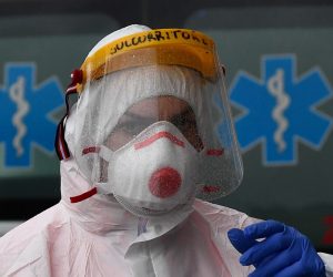 epa08292846 Health workers of the Genoa White Cross wearing protective health masks and overalls get dressed to pick up patients suspected of having contracted the Covid-19 coronavirus, Genoa, Italy, 13 March 2020. Tough lockdown measures kicked in throughout Italy on 12 March after Prime Minister Giuseppe Conte announced late on 11 March that all non-essential shops should close as part of the efforts to contain the ongoing pandemic of the COVID-1.  EPA/LUCA ZENNARO