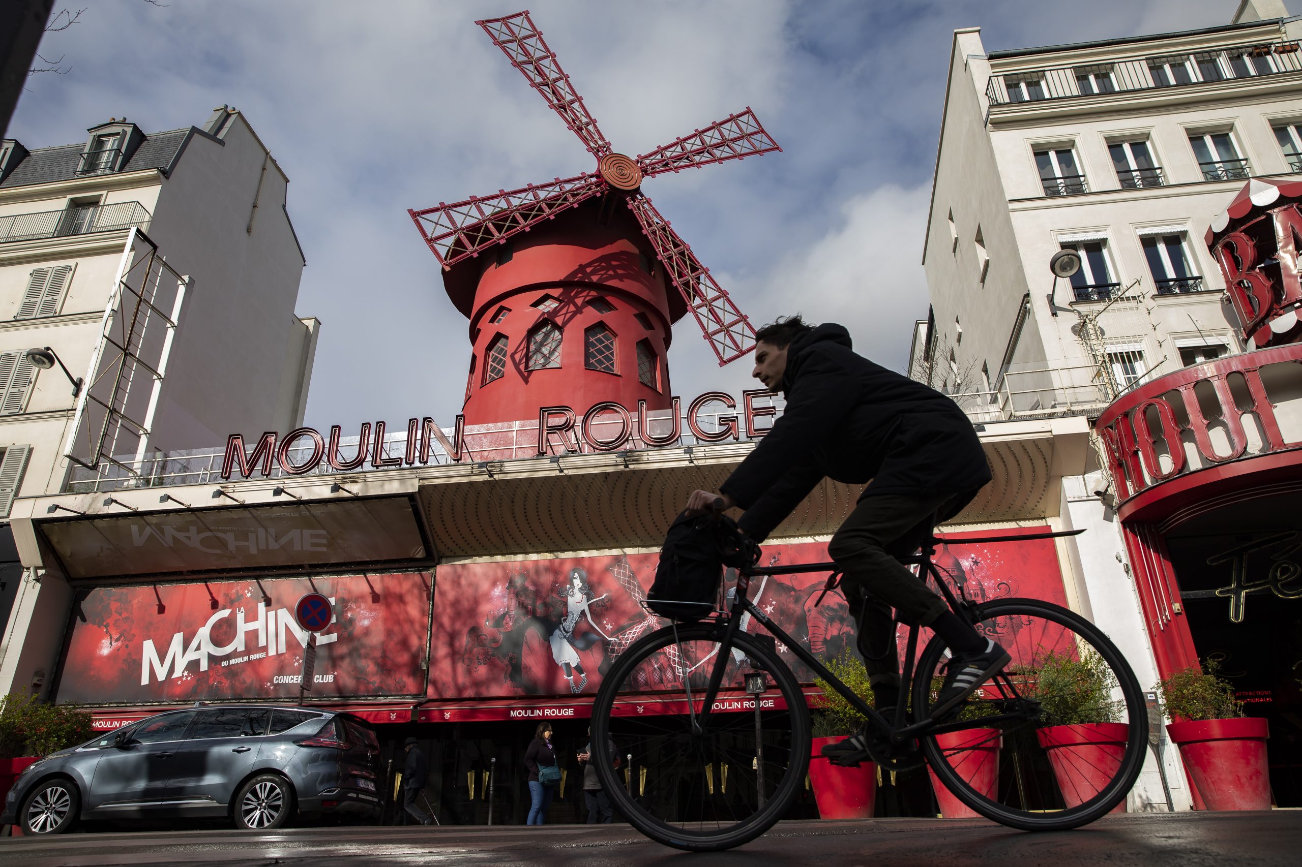 epa08294517 A man cycles past the Moulin Rouge cabaret which closed as part of measures to contain the spread of coronavirus SARS-CoV-2 which causes the Covid-19 disease, in Paris, France, 14 March 2020. France will ban all gatherings of more than 100 people due to the coronavirus pandemic, French Prime Minister Philippe announced on 13 March 2020. President Macron announced the closing of schools, high schools and nurseries from 16 March 2020 on. Over 3,660 cases of COVID-19 infections and 79 deaths have been confirmed so far in France, reports state.  EPA/IAN LANGSDON