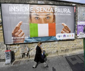 epa08311347 A woman passes a large billboard that reads in Italian 'Together, without fear' referring to the coronavirus Covid19 pandemic, in Naples, Italy, 21 March 2020. The number of deaths from the pandemic COVID-19 disease caused by the SARS CoV-2 coronavirus in Italy has now surpassed the death toll for all of China, where the outbreak originated. According to the Civil Protection agency, the total number of confirmed infections has risen to more than 47,000, while over 4,000 people have lost their lives to the disease in the Mediterranean country.  EPA/CIRO FUSCO
