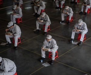 epa08317268 Workers have lunch while sitting 1.5 meters away from others at the joint-venture Dongfeng Honda in Wuhan, Hubei province, China, 23 March 2020 (issued 24 March 2020). The automaker says 95 percent of its labor force has returned to their posts after the long COVID-19 break.  EPA/Yi Xin CHINA OUT
